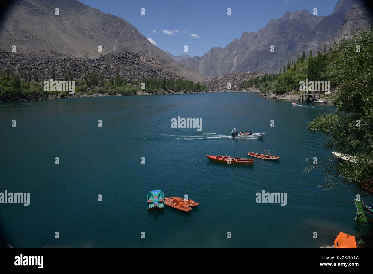 A scenic shot of small red boats floating in Upper Kachura Lake in Pakistan. Stock Photo