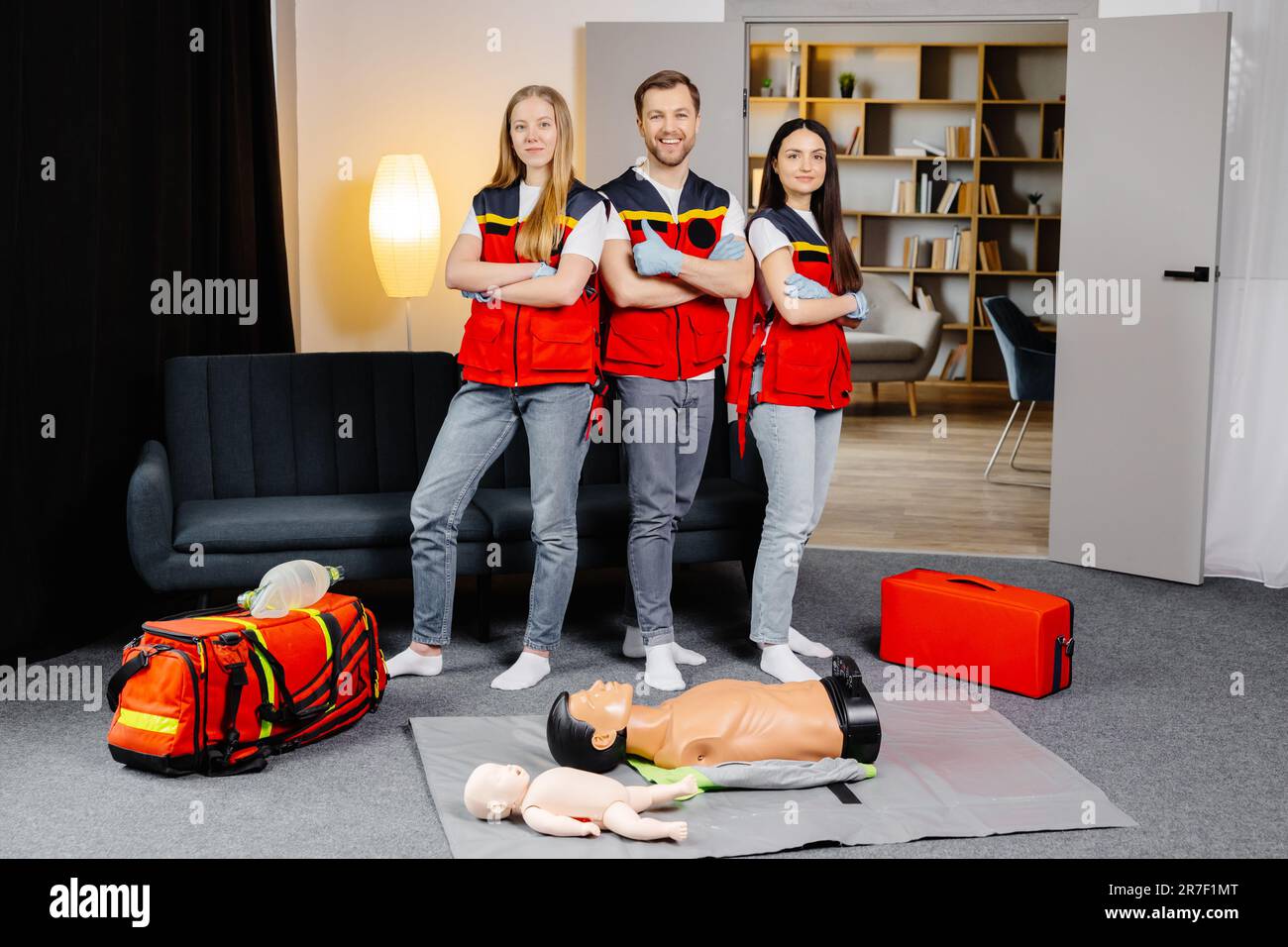 Group of people with cpr dummy looking at camera and smiling after first aid training class. Stock Photo