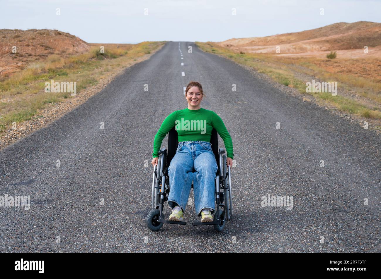 Woman in a wheelchair on a highway in the steppes Stock Photo Alamy