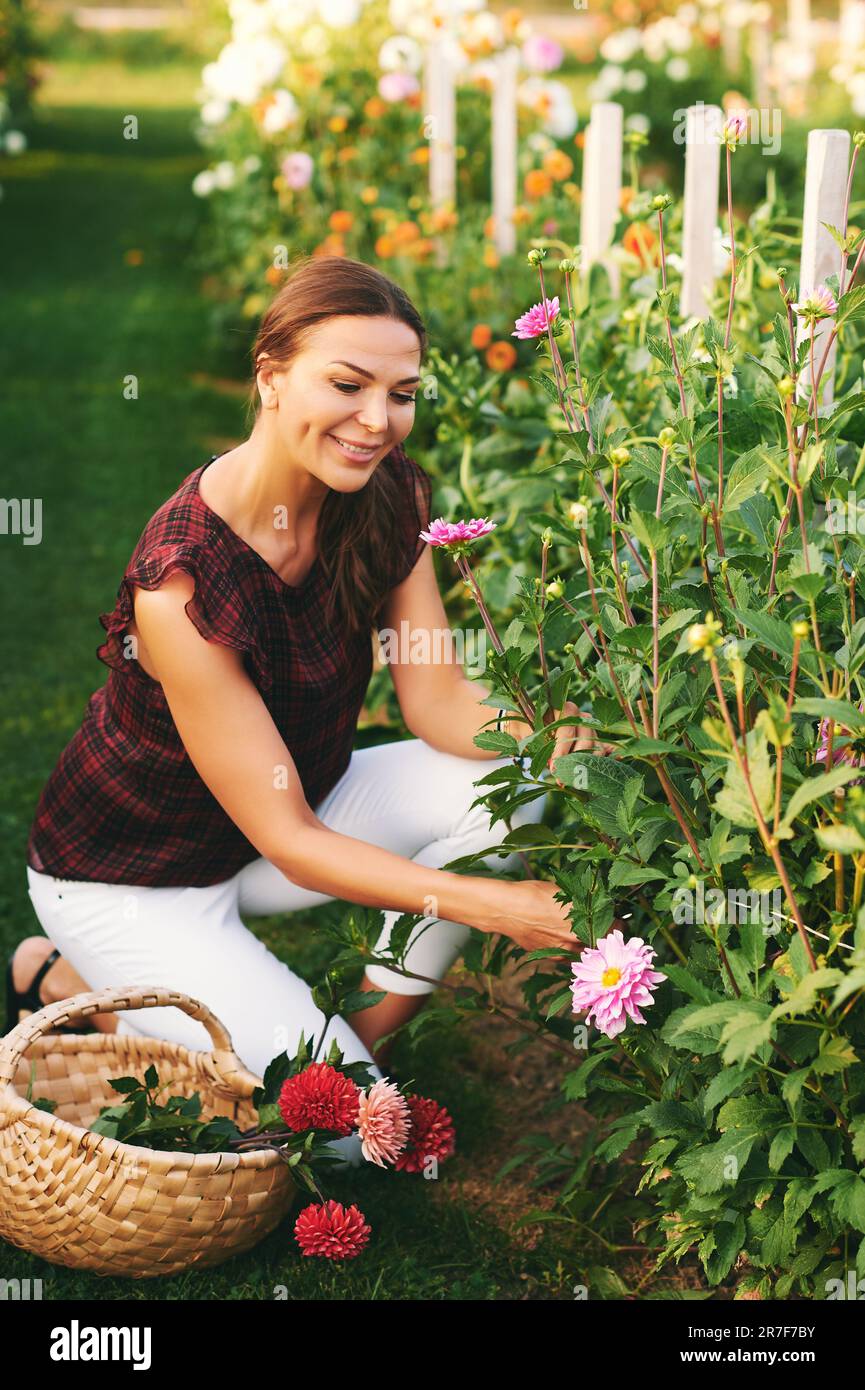 Outdoor portrait of beautiful woman cutting flowers, flower farm, nature lifestyle Stock Photo