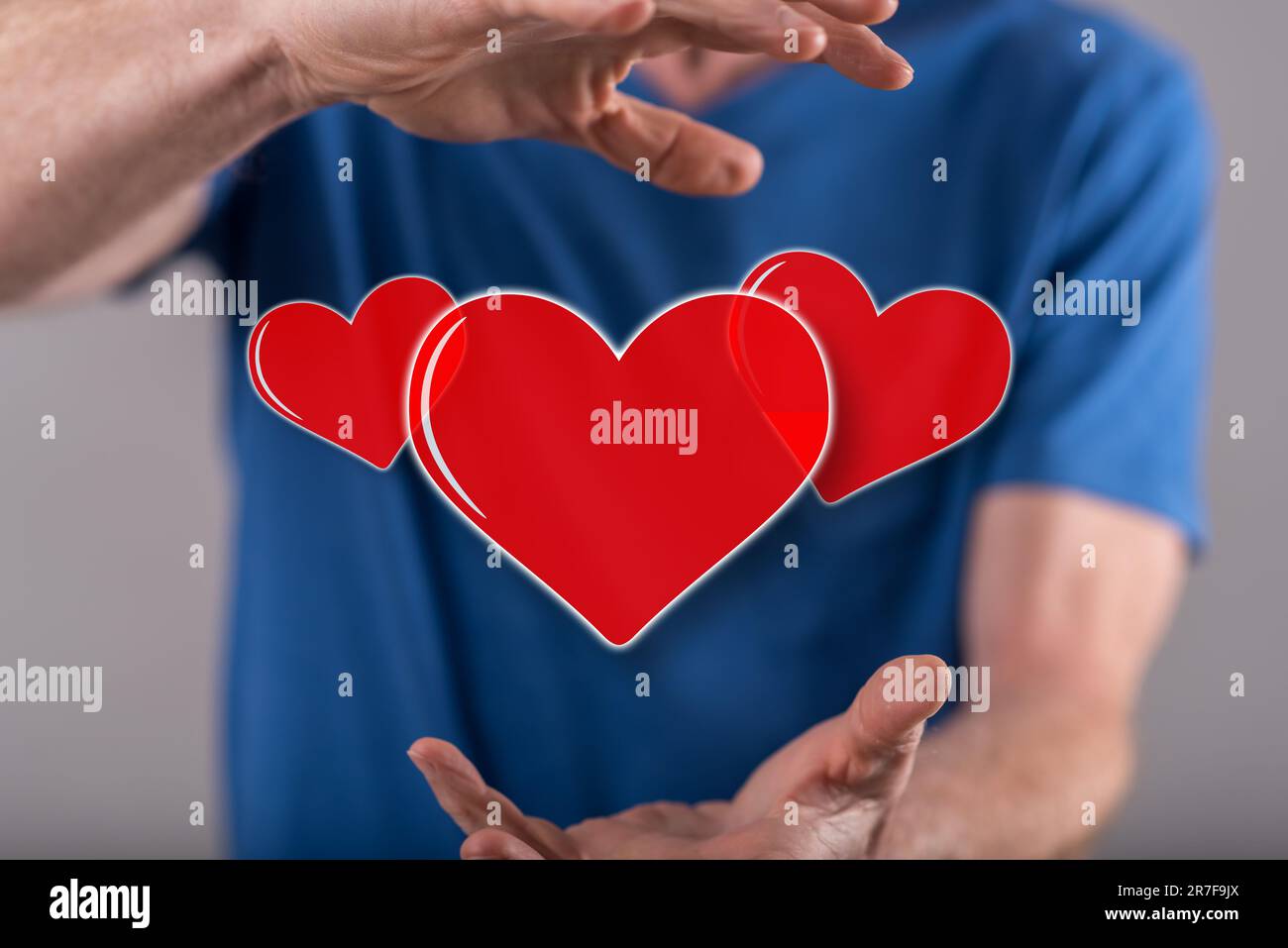 Love concept between hands of a man in background Stock Photo
