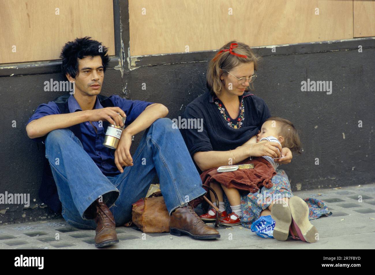 Notting Hill carnival August Bank Holiday Monday 1979.  A young couple with their baby child, exhausted, the child is sleeping in the mothers arms. Everyone is tired out. And the annual annual carnival has hardly begone. Notting Hill, London, England 27th August 1979. 1970s UK HOMER SYKES Stock Photo