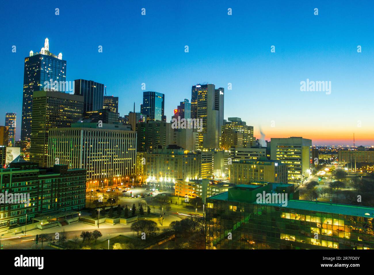 An aerial night view of a bustling city skyline, illuminated by the ...