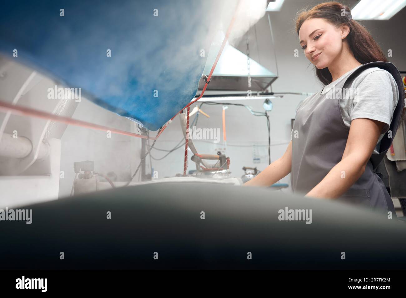 Drycleaning office worker relaxing wrinkles ironing clothes with steam