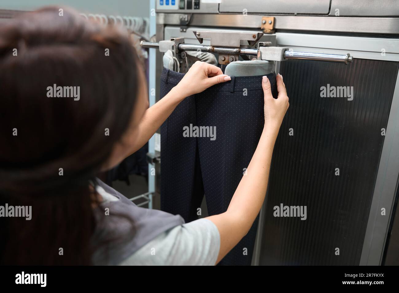 Laundry service worker wearing pants on ironing mannequin Stock Photo