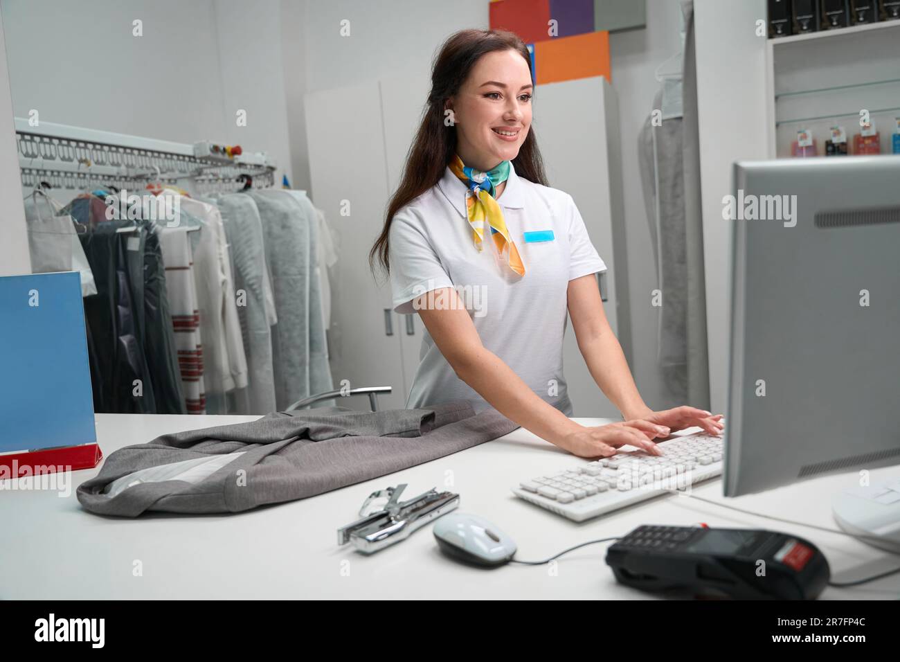 Laundry administrator checking information about clients garment on ...