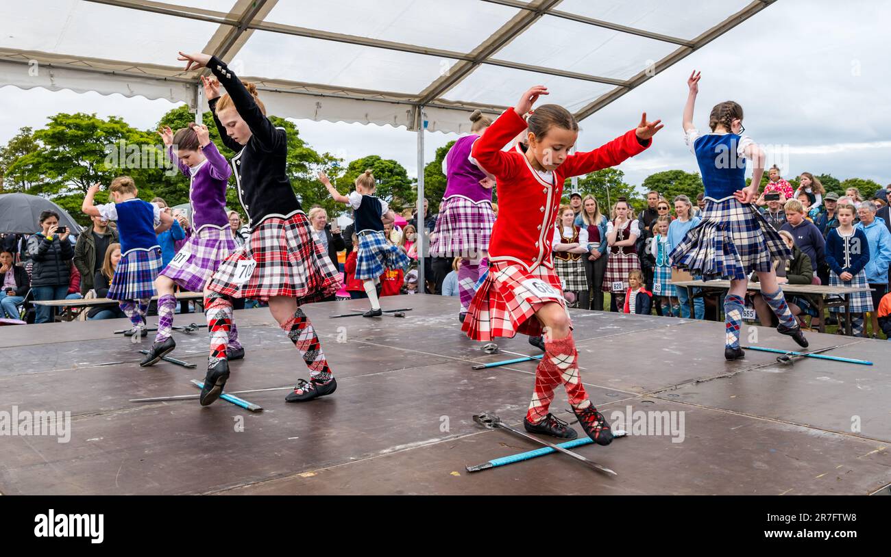 Young girls competing in highland sword dancing event wearing traditional Scottish dress kilts, Highland Games, North Berwick, Scotland, UK Stock Photo