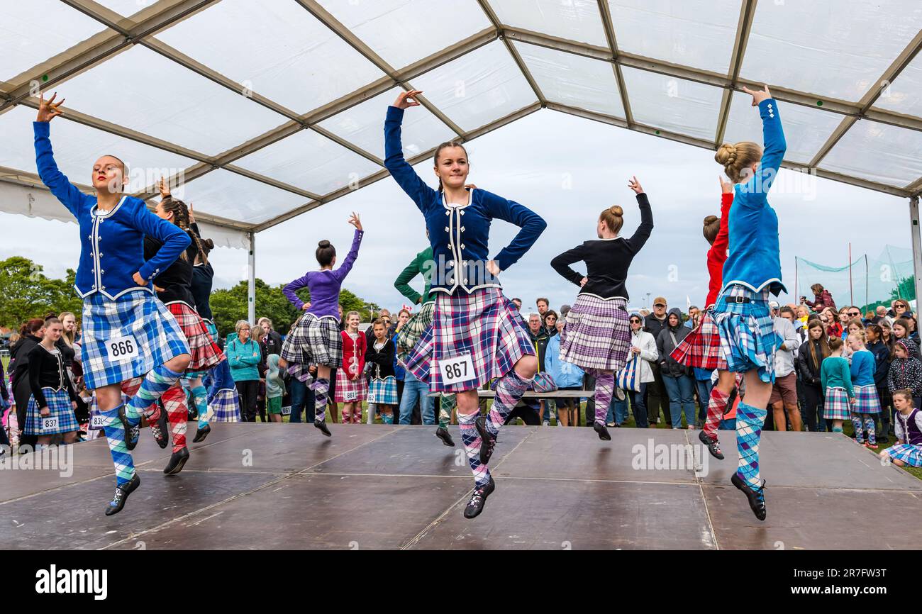 Girls competing in highland dancing event wearing traditional Scottish