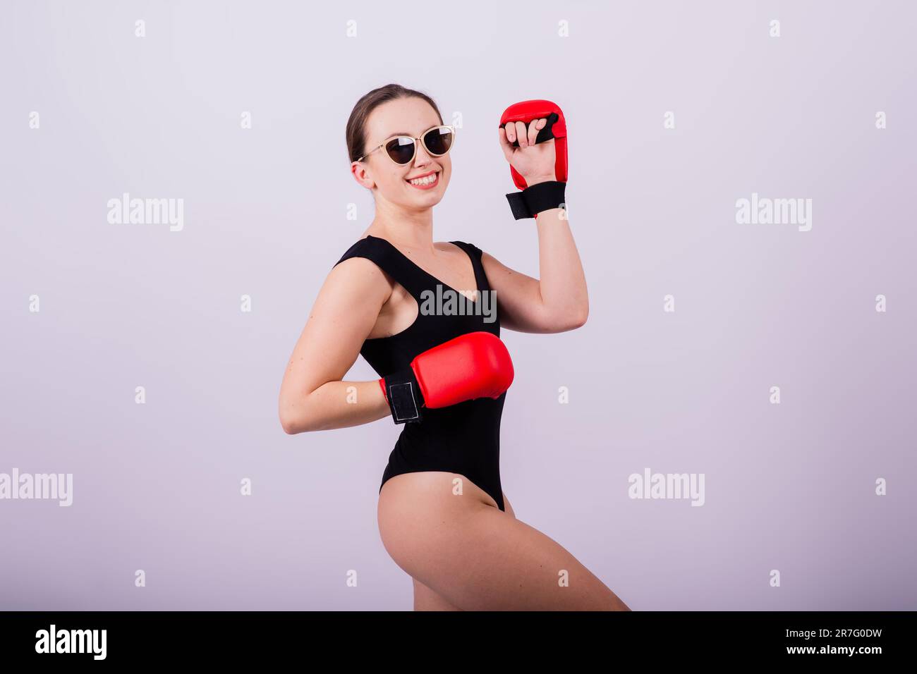 Young Woman In Leotard Doing Fitness Punching Exercises Stock