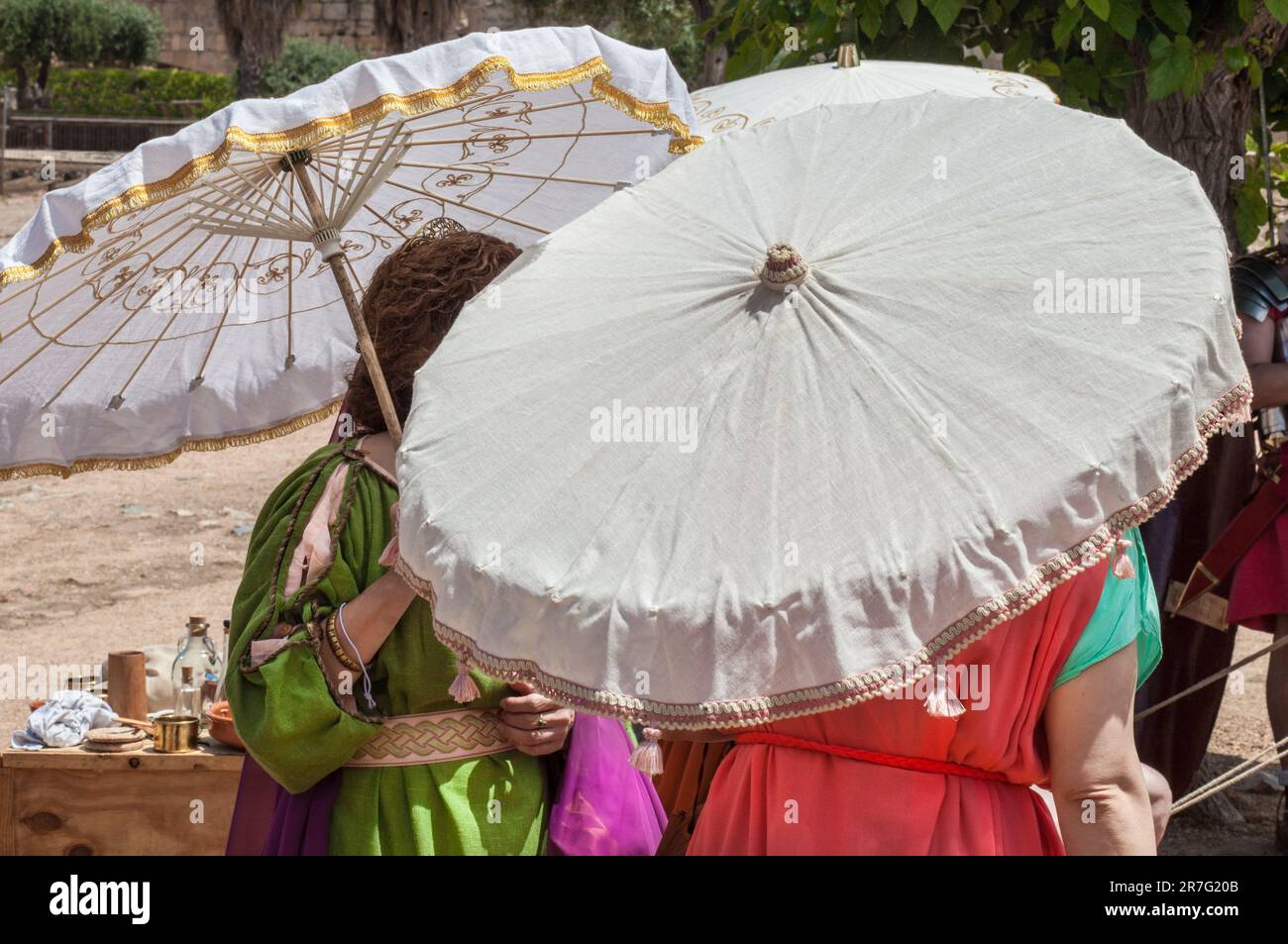 Reenactor women holding umbrella or umbraculum. Fashion in ancient rome Stock Photo