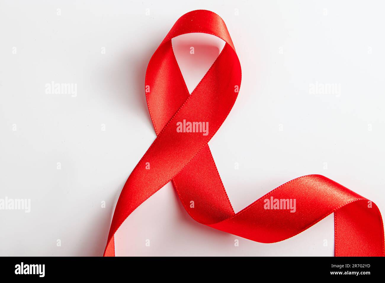 Red silk ribbon for wrapping gifts on white background. Curls of