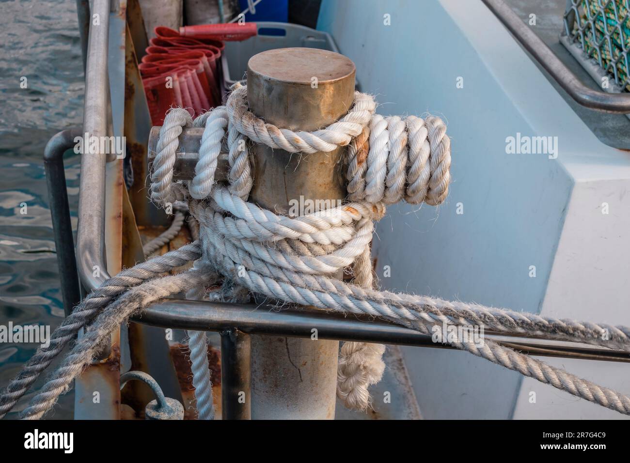 Photograph of white rope wrapped around a steel boat mooring bollard on ...