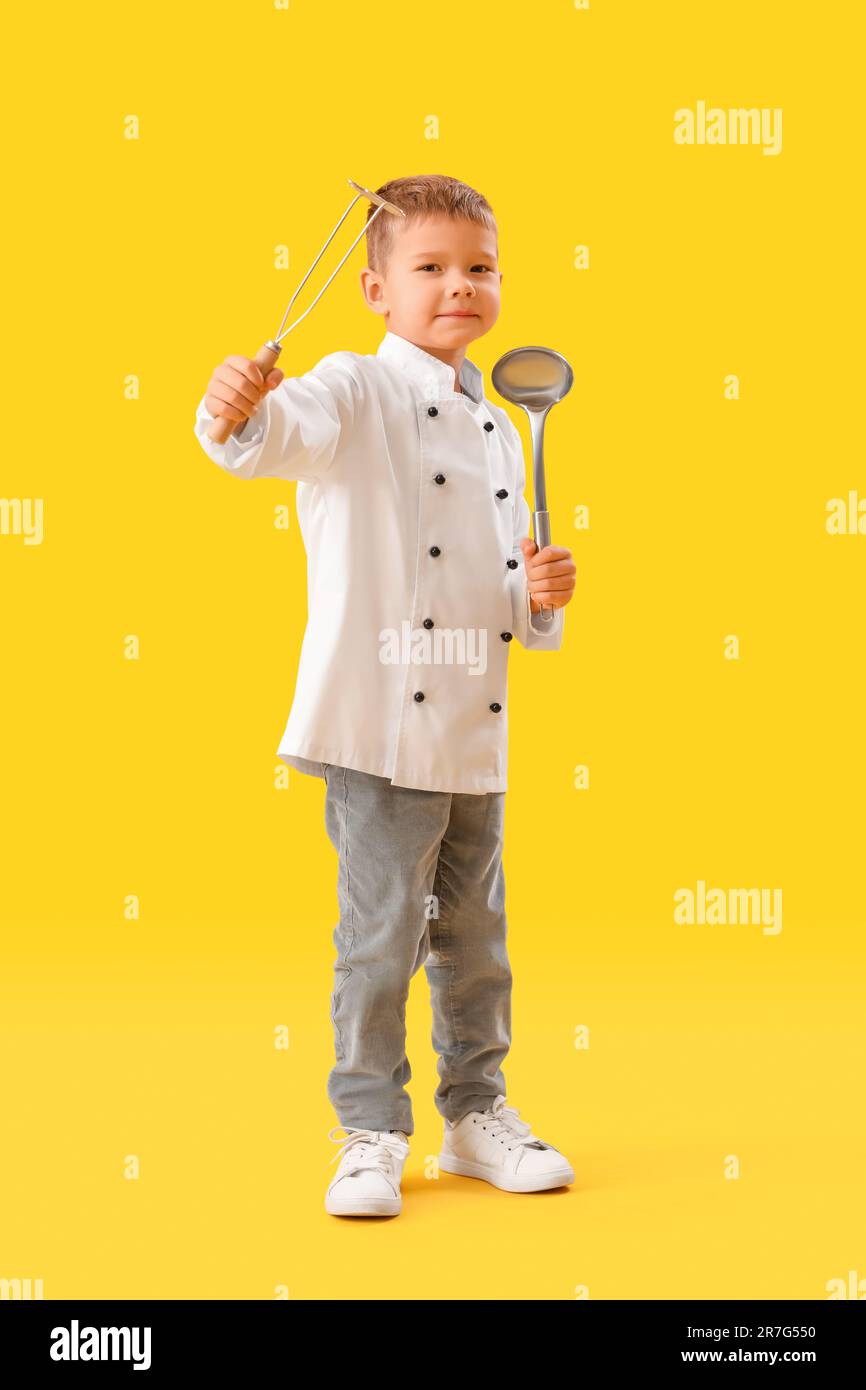 Cute little chef with supplies on yellow background Stock Photo - Alamy