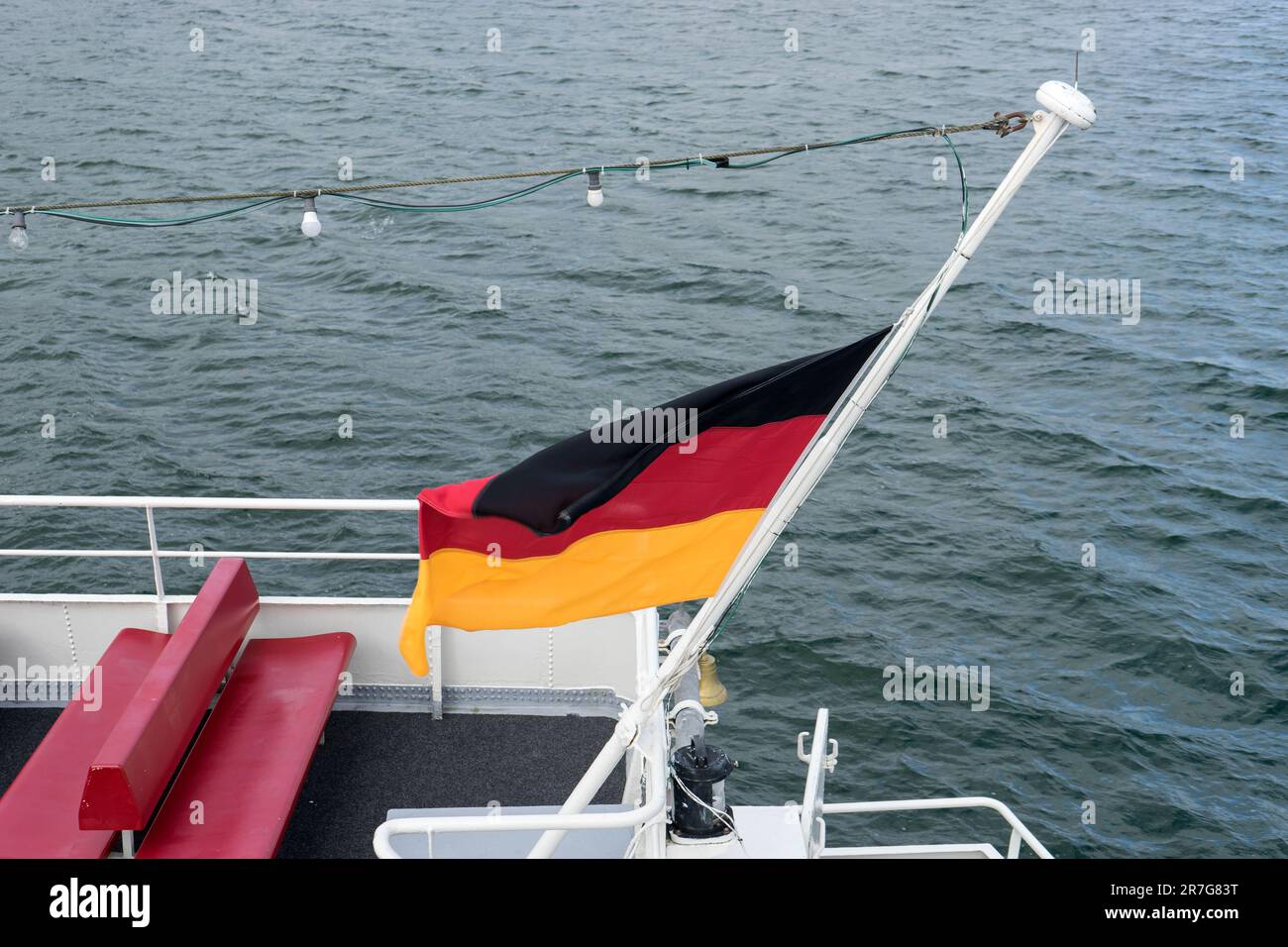 German flag on a ship at halfmast during a burial at sea Stock Photo