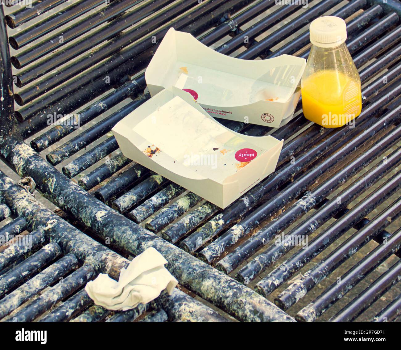 discarded fast food on a bench litter Stock Photo
