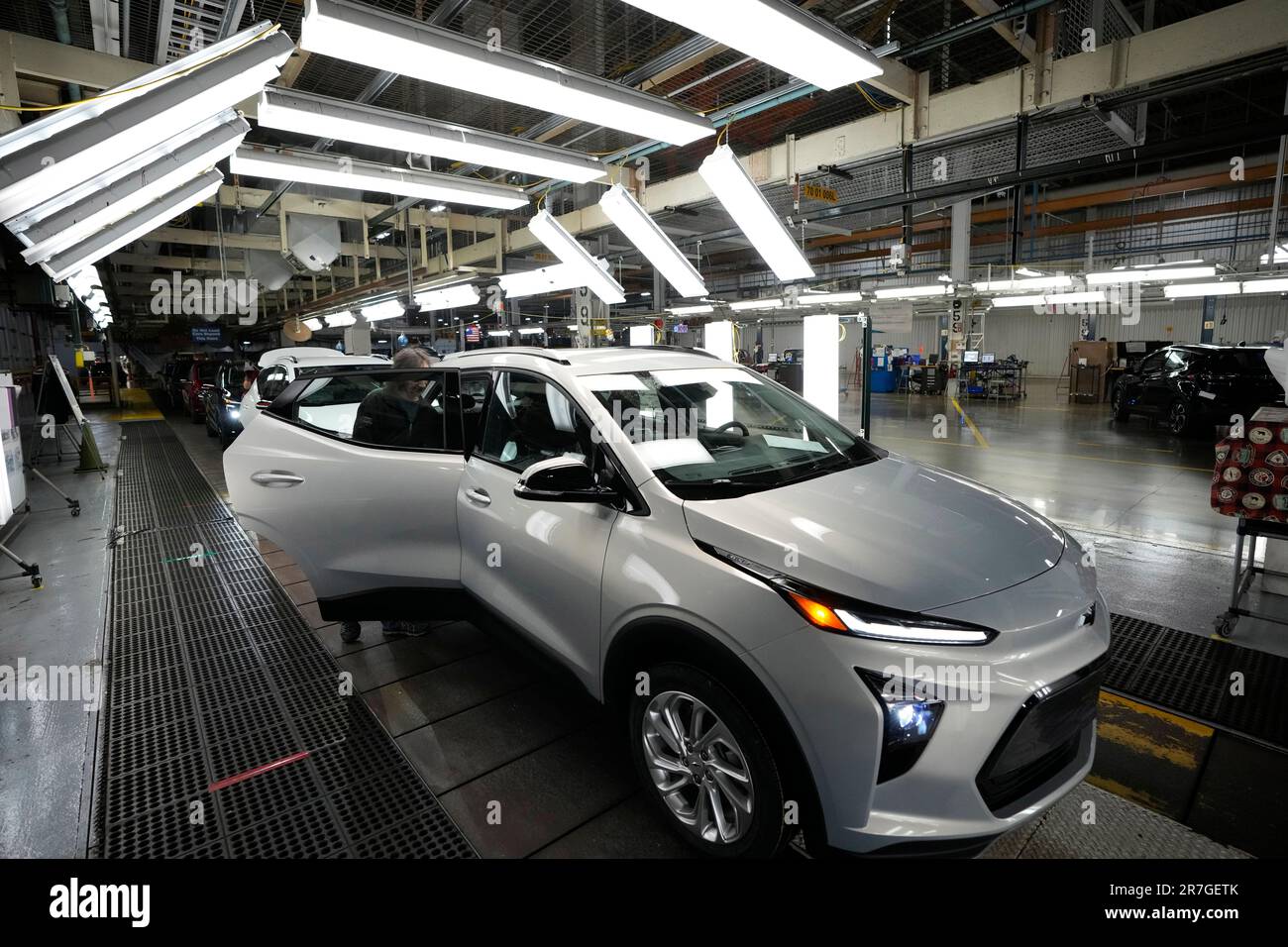 An assembly line worker looks over a 2023 Chevrolet Bolt EUV at the General Motors Orion