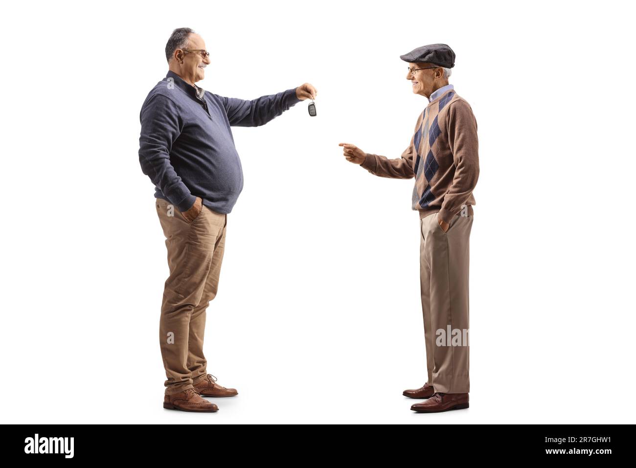 Mature man giving car keys to an elderly man isolated on white background Stock Photo