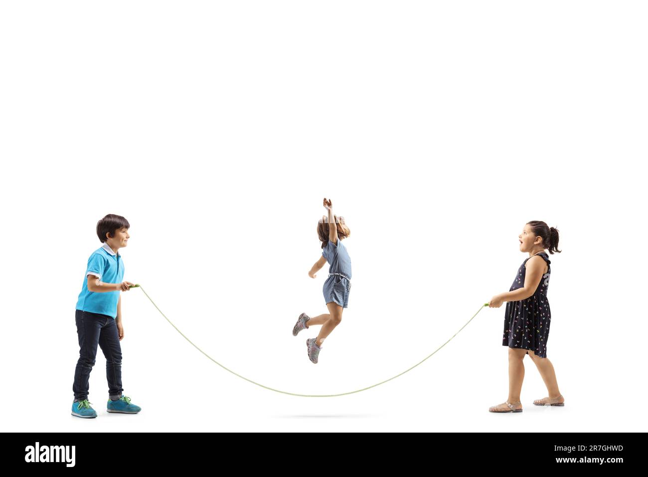 Full length profile shot of a boy and two girls playing skipping rope isolated on white background Stock Photo