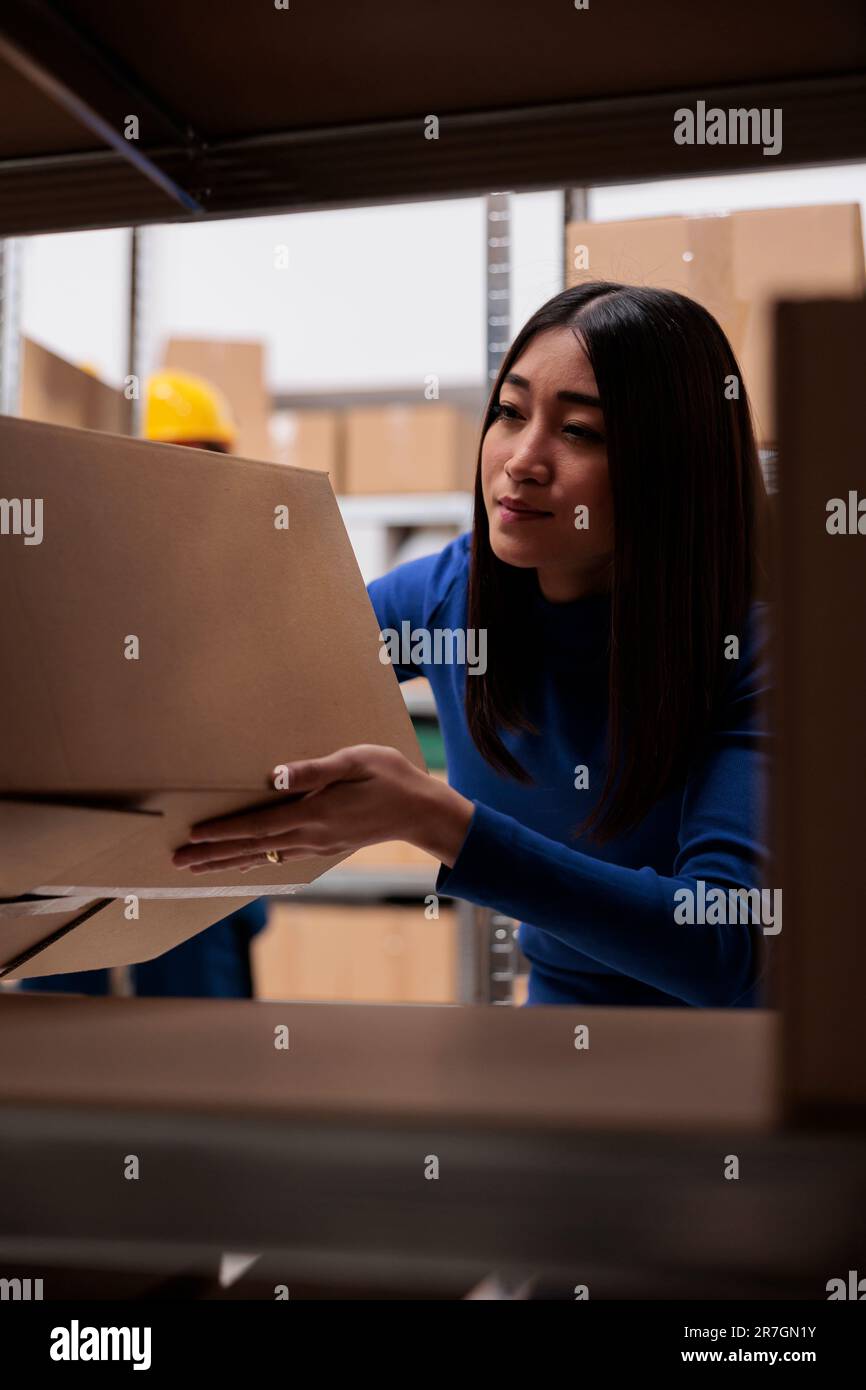 Goods supply chain manager doing inventory in warehouse while checking ...