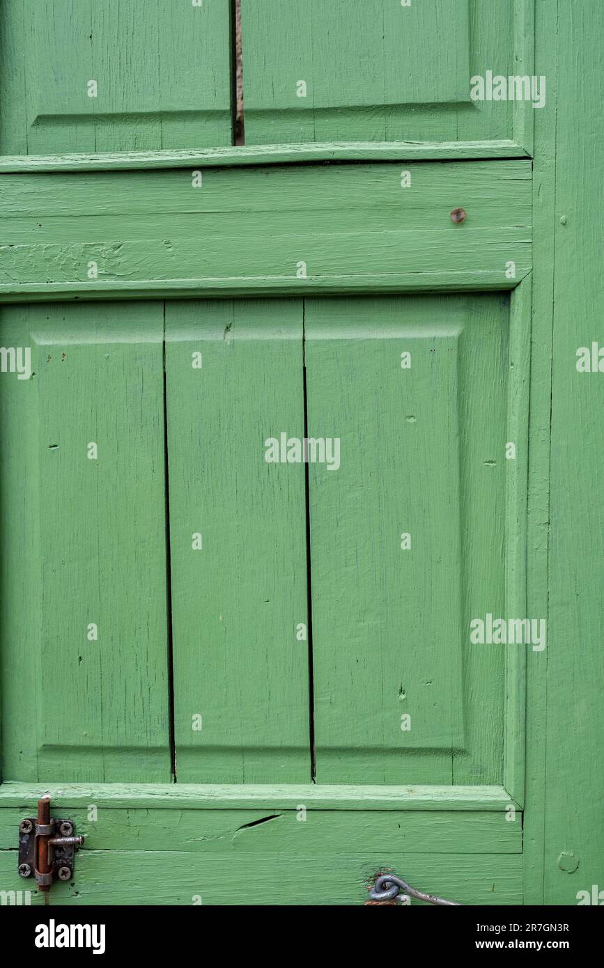Beautiful green wood jalousie on windows of renovated old building. Stock Photo