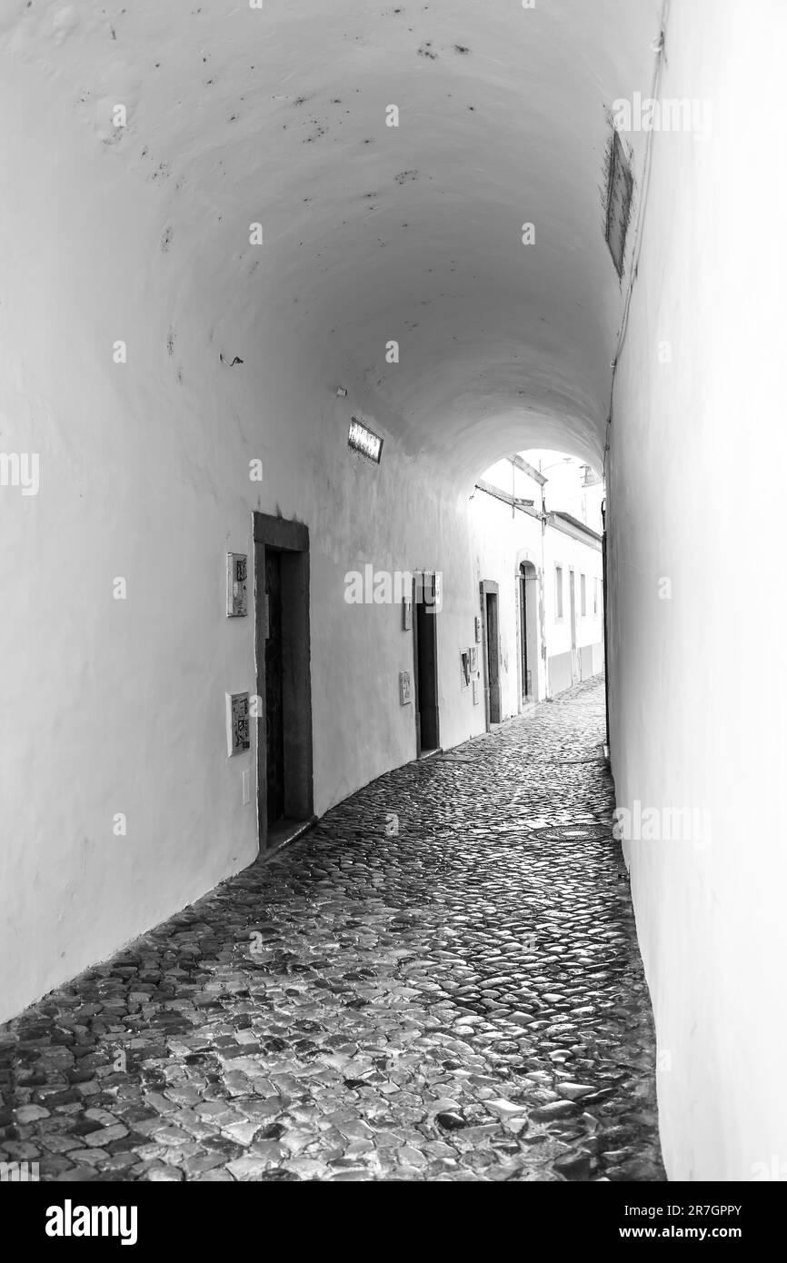Tavira, Portugal- October 20, 2022: Narrow cobblestone street and traditional facades with bright colors in Tavira town, Portugal Stock Photo