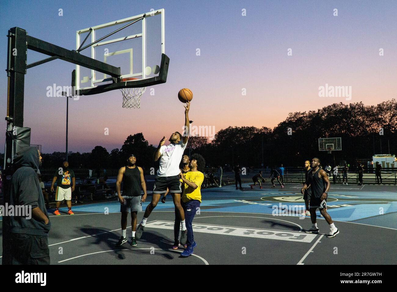 UK weather, Clapham, London, 15 June 2023: On a light summer evening after a hot day, basketball players make use of floodlit courts on Clapham Common to get some practice in. Credit: Anna Watson/Alamy Live News Stock Photo