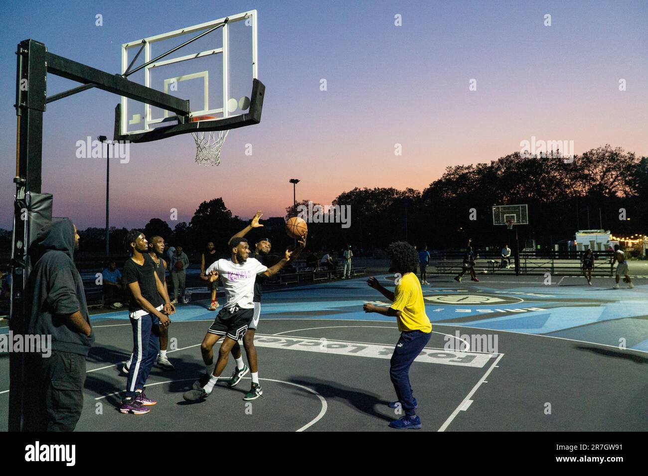 UK weather, Clapham, London, 15 June 2023: On a light summer evening after a hot day, basketball players make use of floodlit courts on Clapham Common to get some practice in. Credit: Anna Watson/Alamy Live News Stock Photo