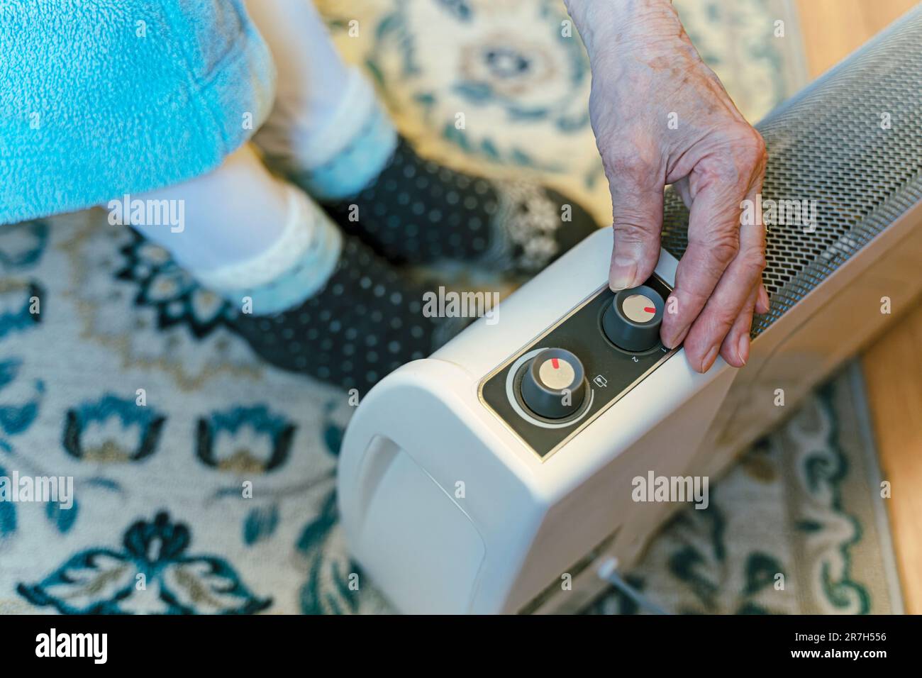 Electric Space Heater, Elderly Woman Wearing Thick Socks Stock Photo