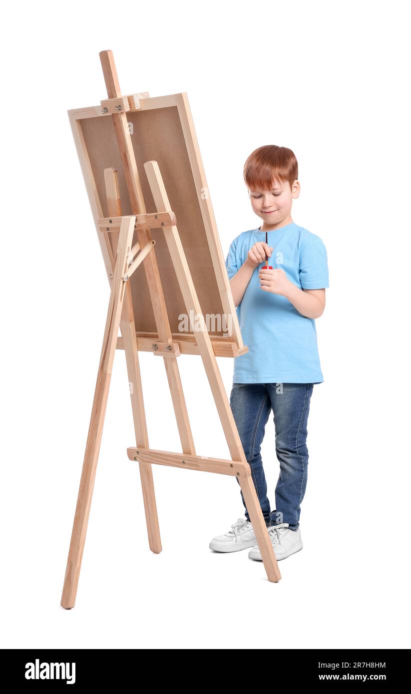 Little boy painting against white background. Using easel to hold canvas Stock Photo Alamy