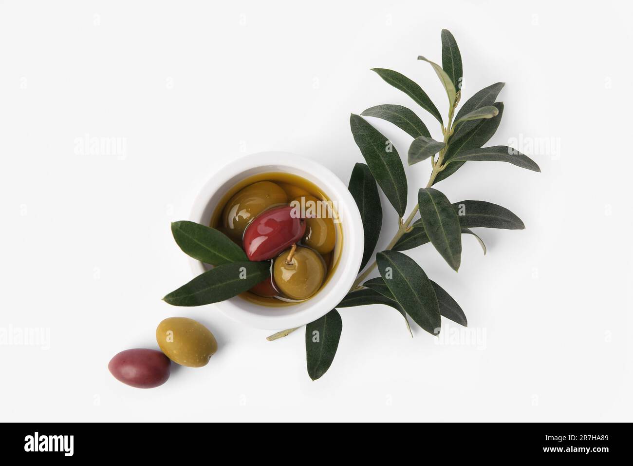 Bowl with different ripe olives and leaves on white background, flat lay Stock Photo