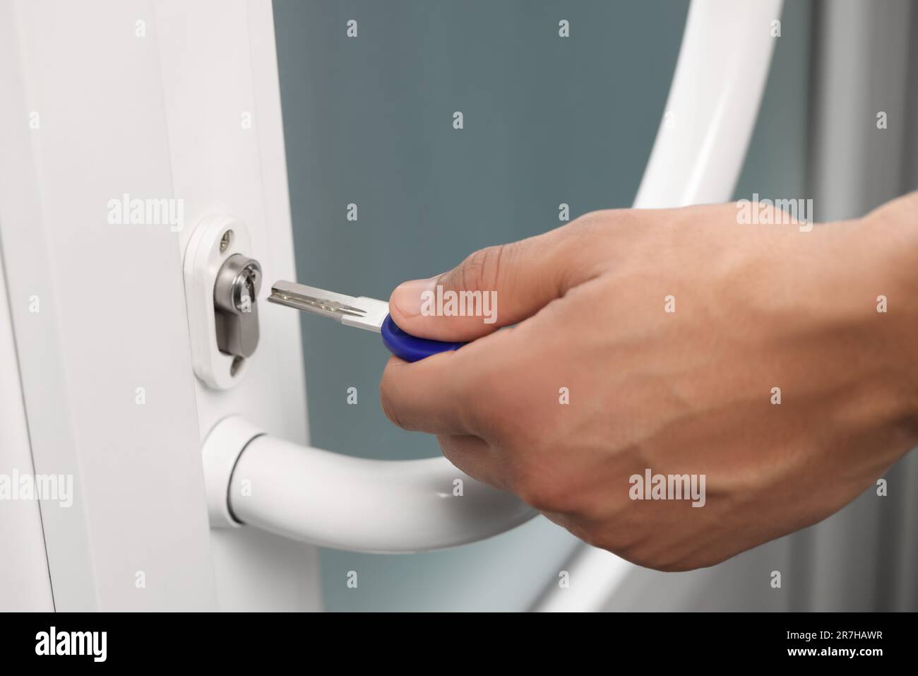 Man unlocking door with key, closeup view Stock Photo