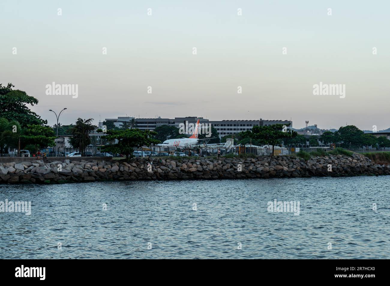 South end view of Santos Dumont airport at the Guanabara bay waters in Centro district as saw from Rock Pier under summer late afternoon sunset sky. Stock Photo