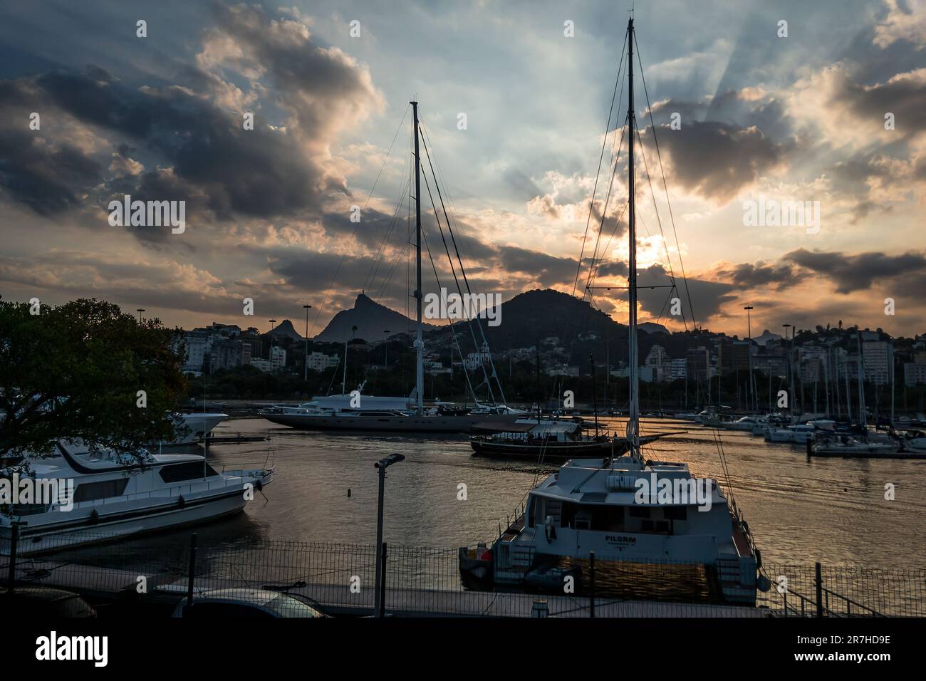 Boats, yachts and vessels anchored with others sailing in between at Gloria marina in Gloria district under summer late afternoon clouded sunset sky. Stock Photo