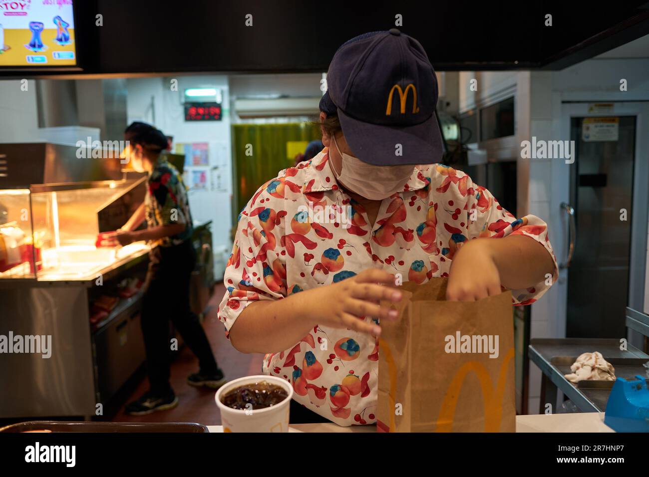 PATTAYA, THAILAND - CIRCA APRIL, 2023: McDonald's fast food restaurant employee with order in Pattaya. Stock Photo