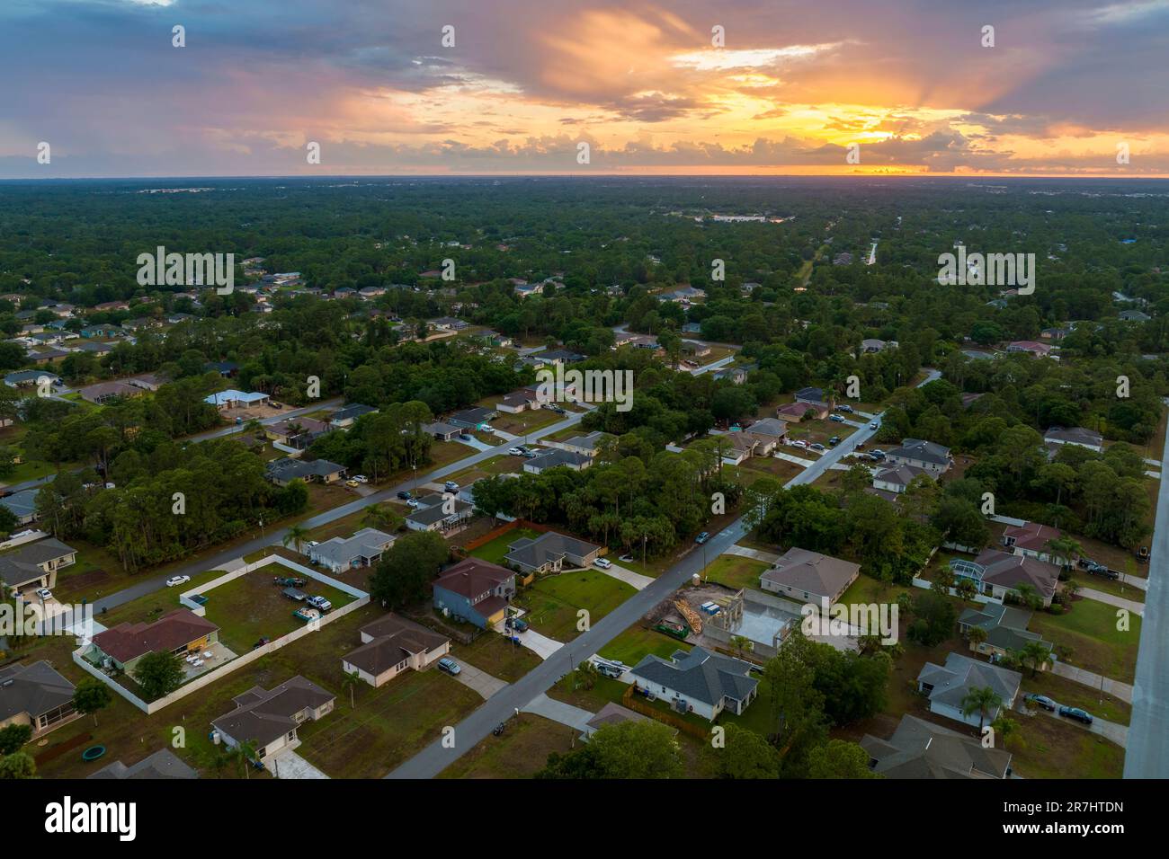Aerial view of suburban landscape with private homes between green palm