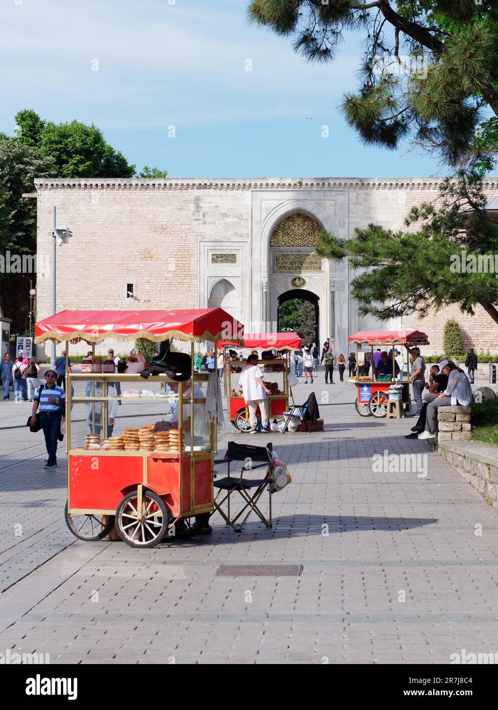 Red carts with simits (Turkish Bagels) outside the Imperial Gate, the outer most gate of the Topkapi Palace historic Ottoman complex, Istanbul, Turkey. Stock Photo