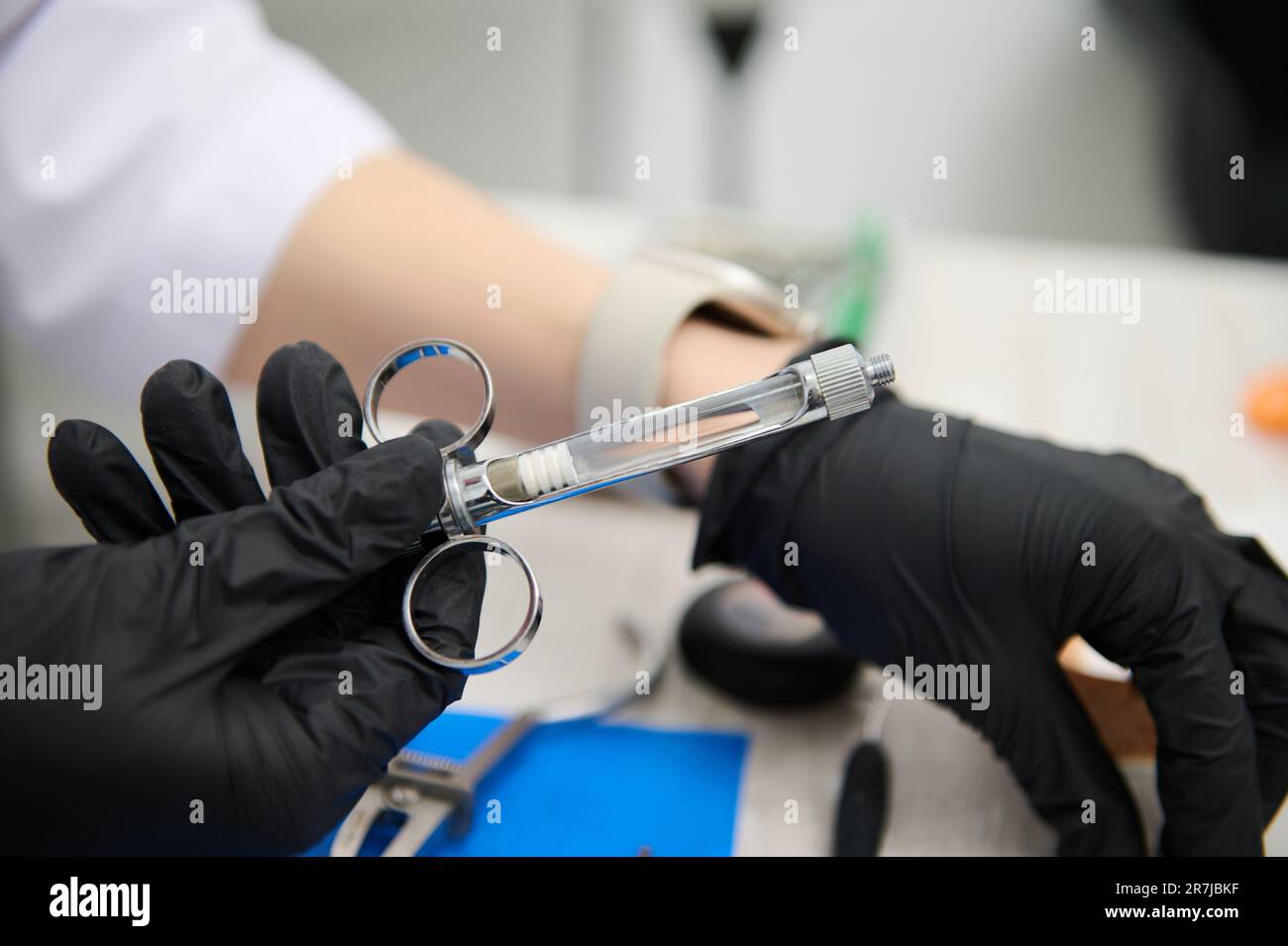 Syringe with anesthetic in hands of dentist preparing anelgesic