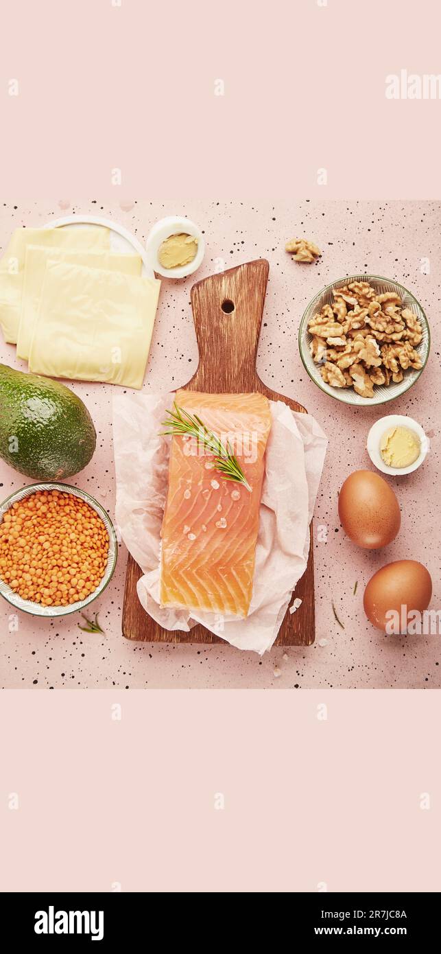 Natural proteins. Smoked salmon, cheese, avocado, eggs, lentils, walnuts on pink background. Healthy lifestyle. Copy space. Stock Photo