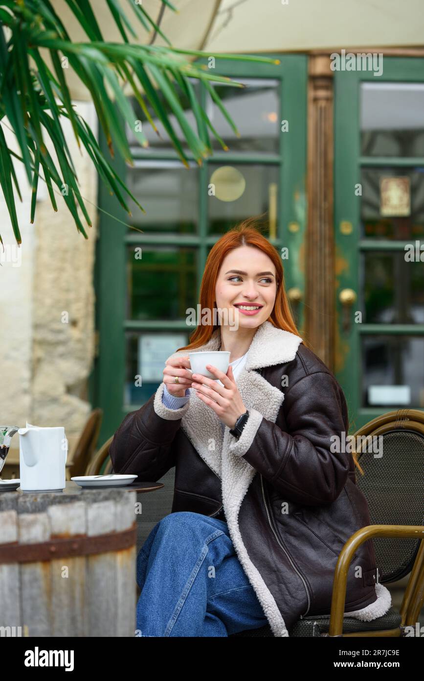 a red-haired girl in a leather jacket. cheerful woman with long red ...