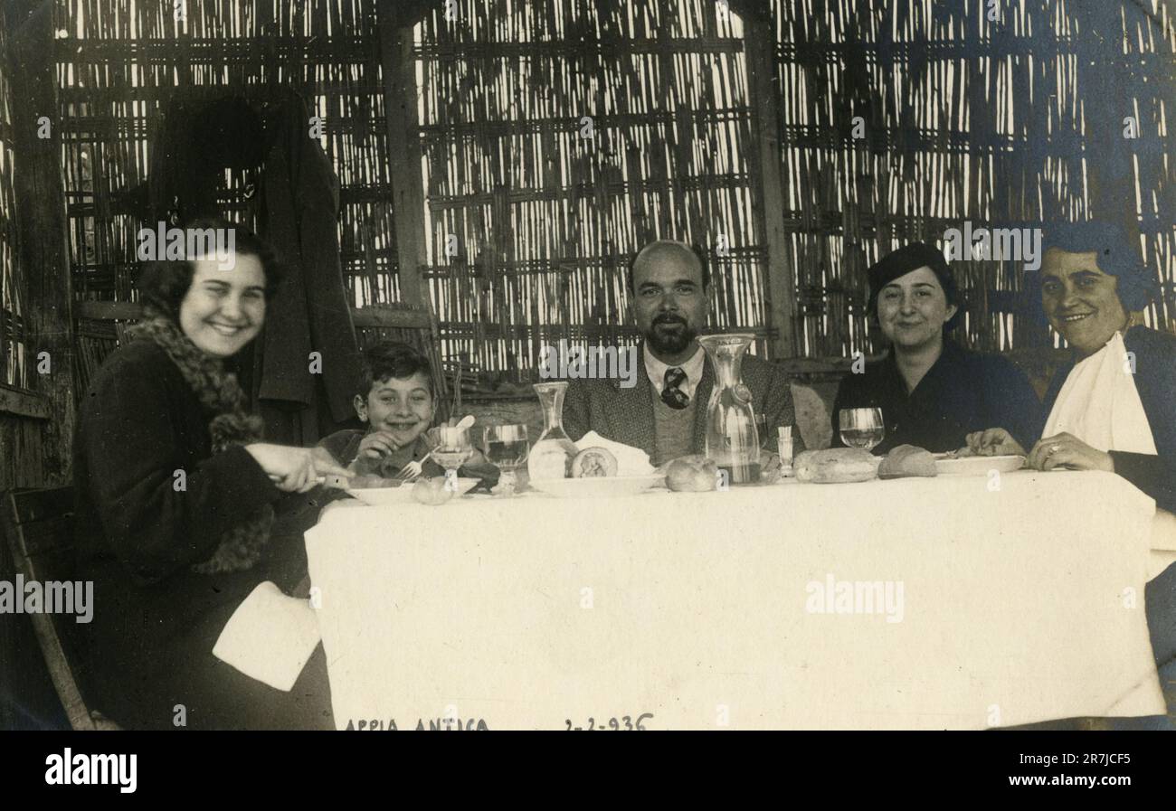 Italian family having lunch outside in a fraschetta in Via Appia Antica, Rome 1936 Stock Photo