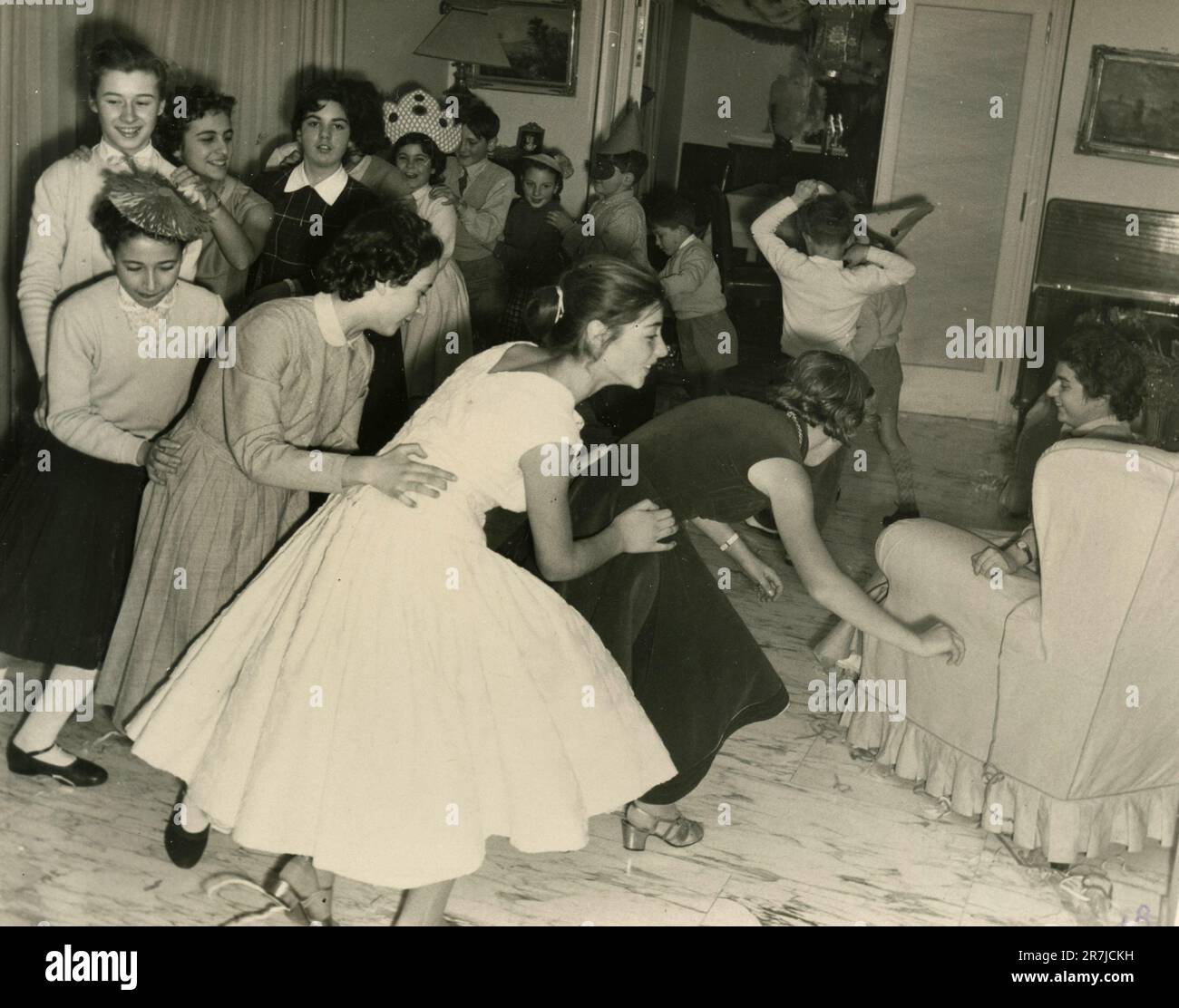 Group of teenagers and children dancing during a home party, Italy 1960s Stock Photo