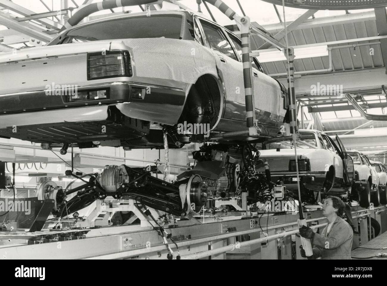 XJ40 body lowered onto engine and suspention assembly at the Jaguar car factory of Browns Lane plant, UK 1986 Stock Photo