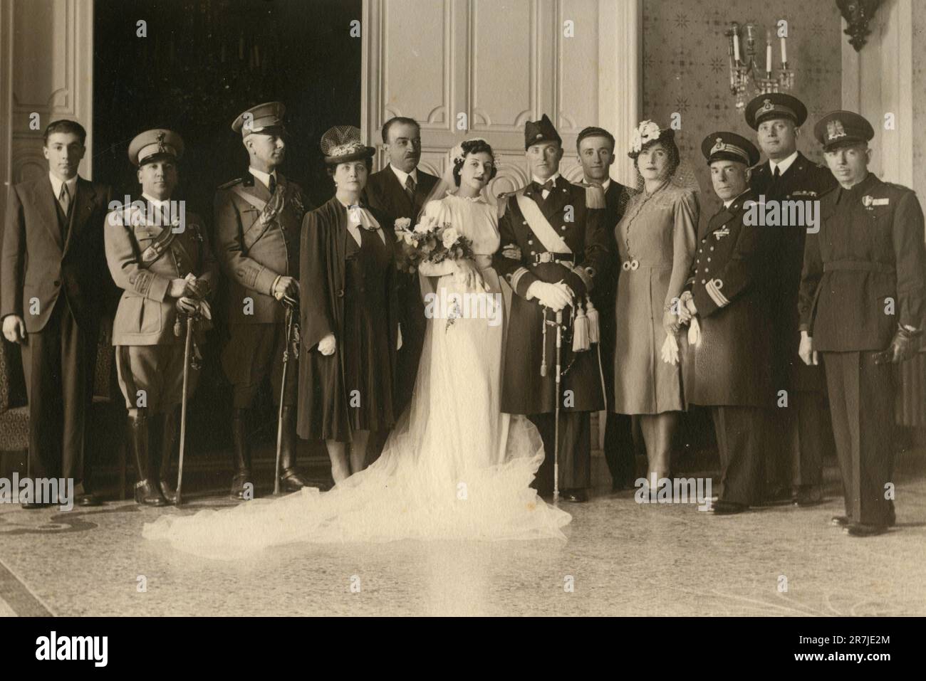 Group of mostly uniformed men taking the photo with the just married, Italy 1930s Stock Photo