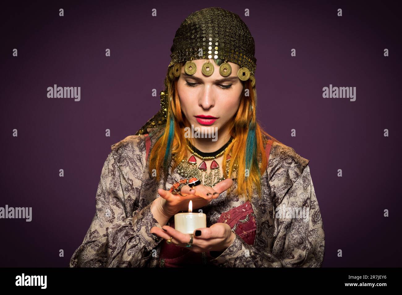 Serious female fortune teller in gypsy outfit and headwear putting hand ...