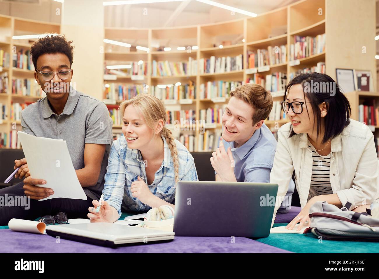 Group of content multi-ethnic university students sitting in library ...