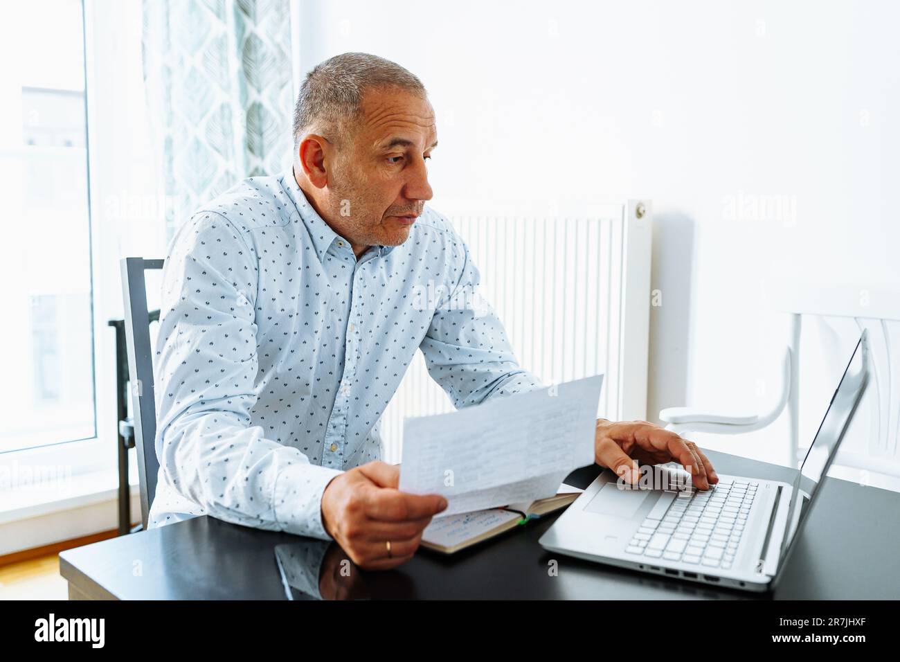 Portrait middle-aged man making notes in notebook Stock Photo