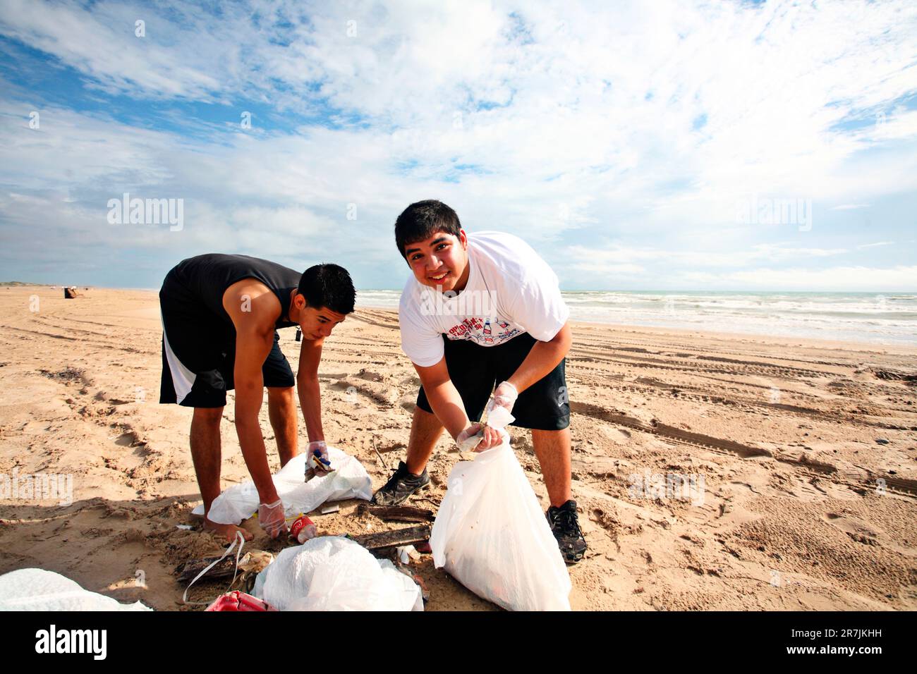 Two friends pick up trash on the beach on S.Padre Island Stock Photo