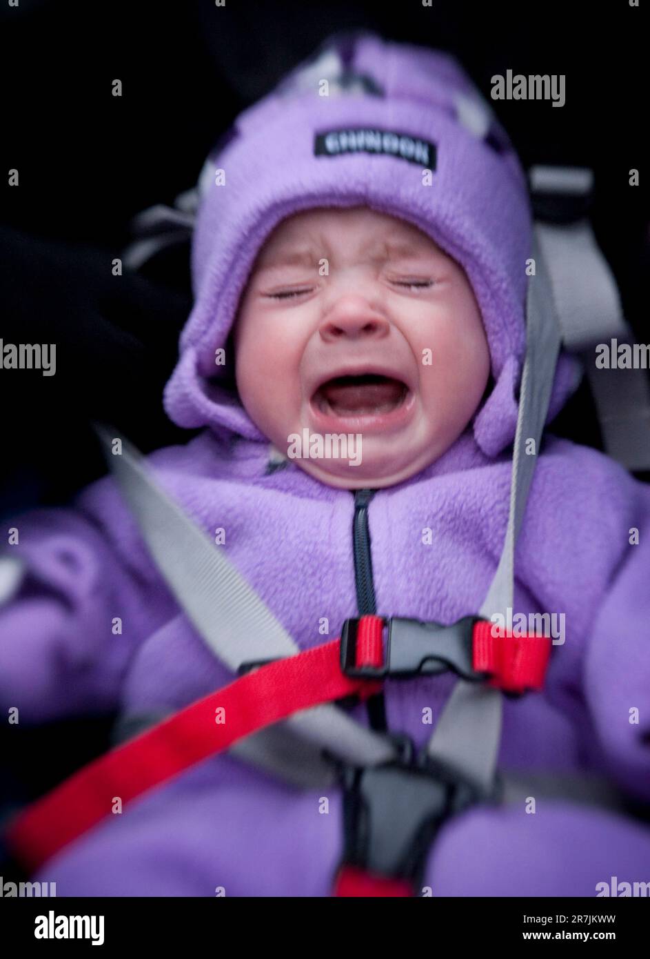 A baby bundled up for winter cries in her stroller Stock Photo Alamy