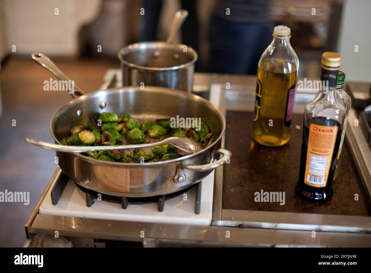A pan of cooked organic brussel sprouts sits on a stovetop in a home kitchen in Portland, Oregon. Stock Photo