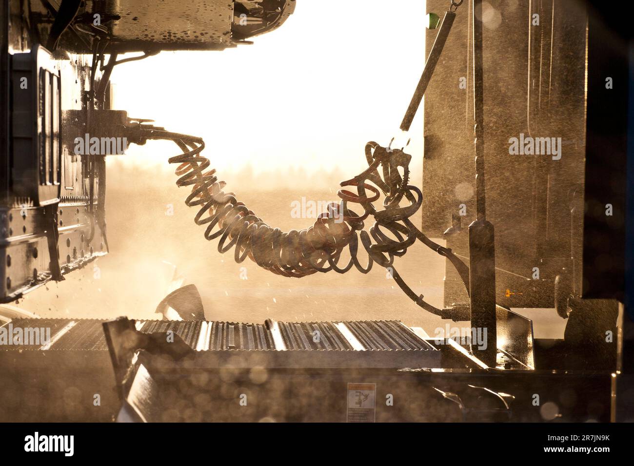 Light shines through the rain and exposes the mechanics between the cab